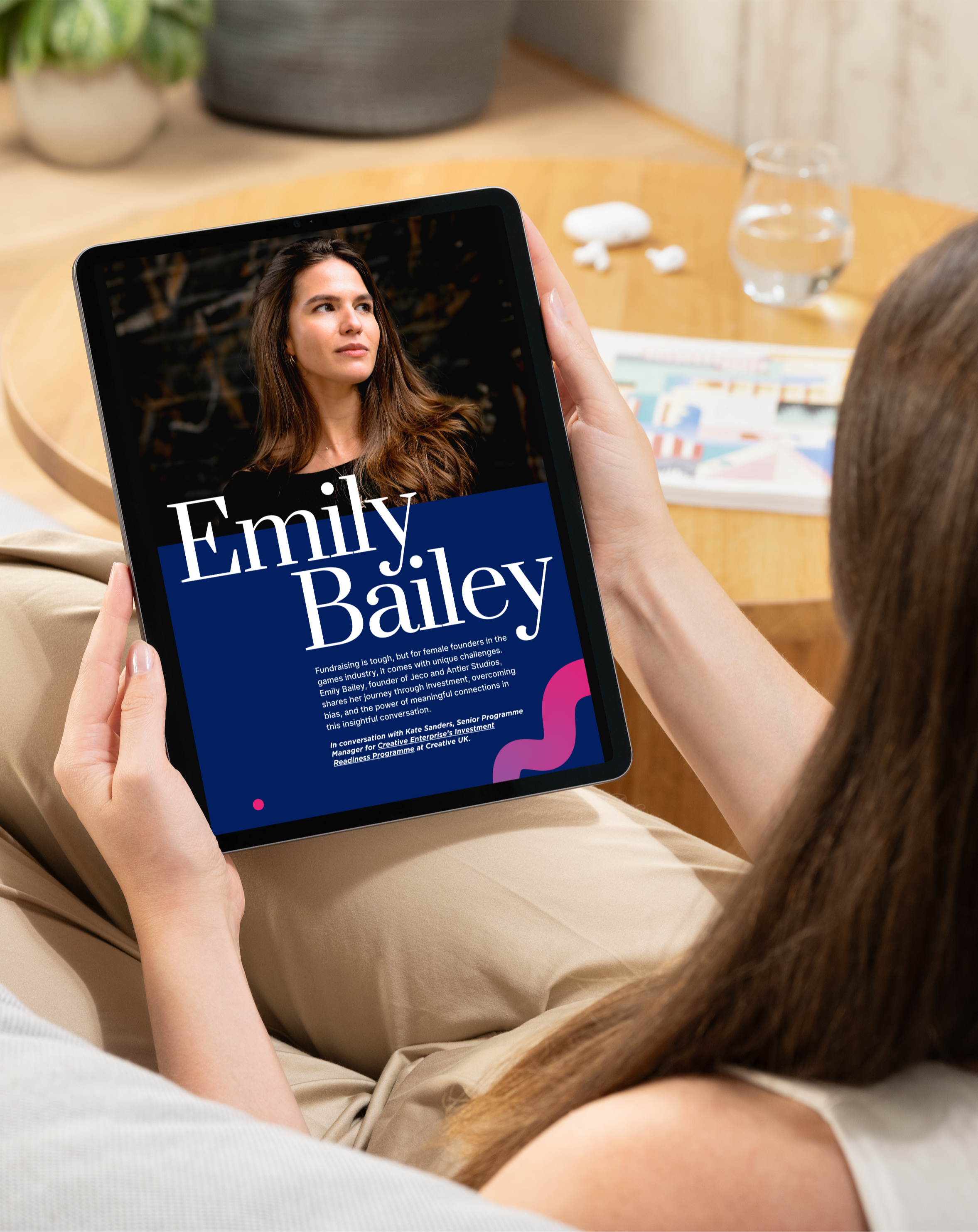 Person reading the Female Founders Magazine on a tablet, featuring Emily Bailey’s profile on challenges and successes in games industry fundraising.